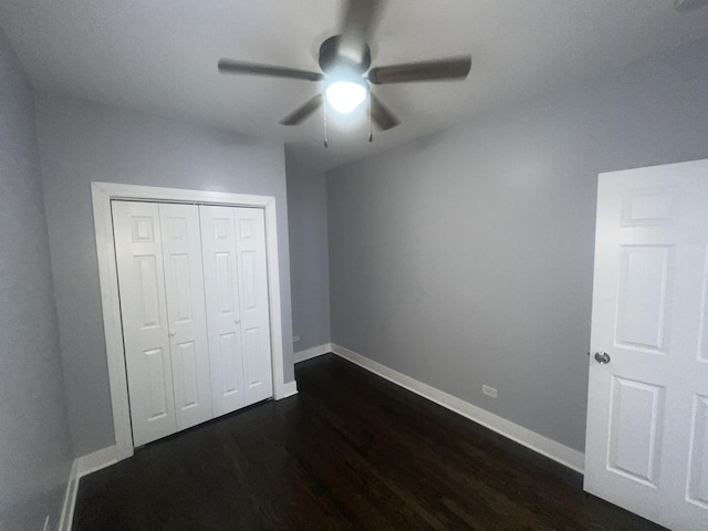 unfurnished bedroom featuring ceiling fan, dark hardwood / wood-style floors, and a closet