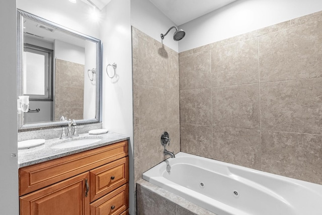 bathroom with tiled shower / bath combo and vanity