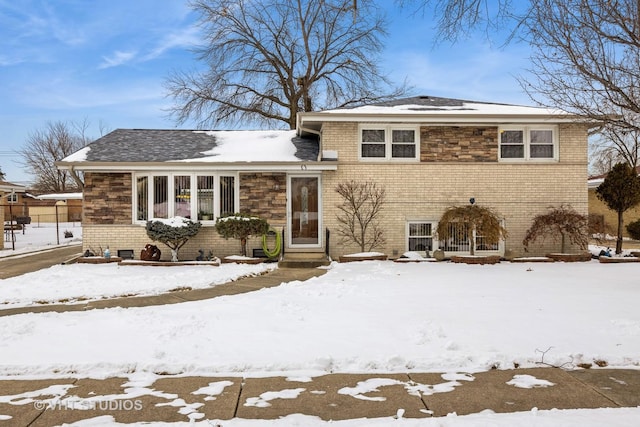 tri-level home featuring brick siding