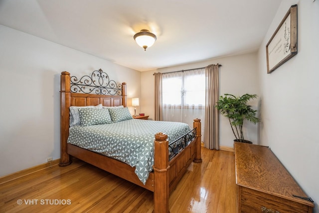 bedroom featuring light wood-style floors and baseboards