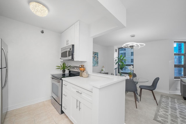 kitchen featuring white cabinetry, stainless steel appliances, light tile patterned floors, and kitchen peninsula