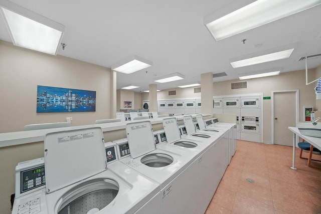 laundry area featuring light tile patterned flooring, independent washer and dryer, and stacked washer / dryer