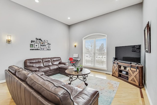 living room featuring light wood-type flooring, baseboards, and recessed lighting