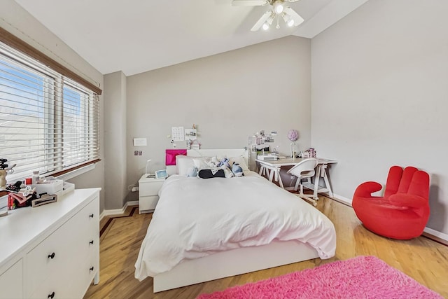 bedroom with lofted ceiling, baseboards, a ceiling fan, and light wood-style floors