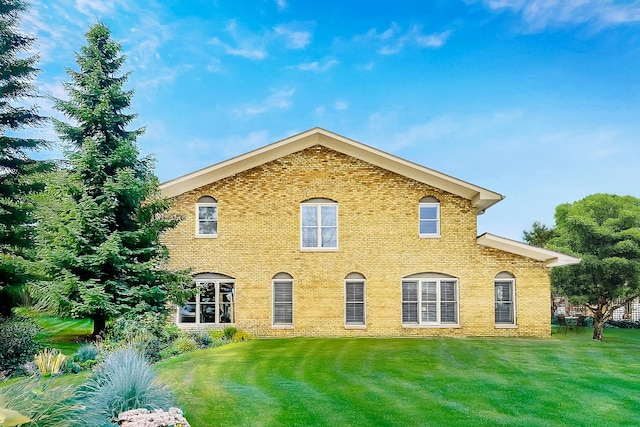 exterior space featuring brick siding and a yard