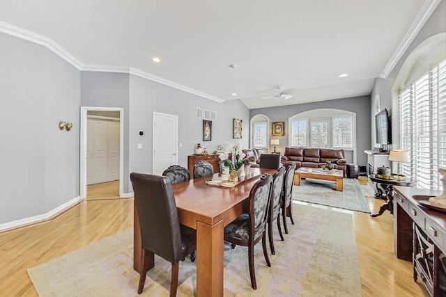 dining space with baseboards, light wood-type flooring, visible vents, and crown molding