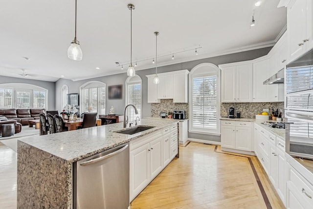 kitchen featuring stainless steel appliances, a sink, open floor plan, an island with sink, and decorative light fixtures