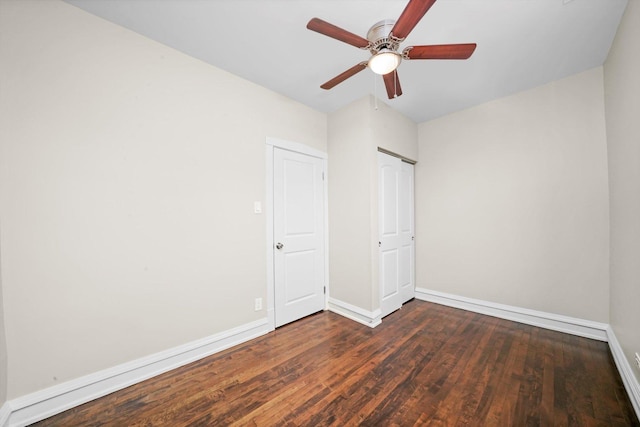 unfurnished bedroom featuring ceiling fan and dark hardwood / wood-style flooring