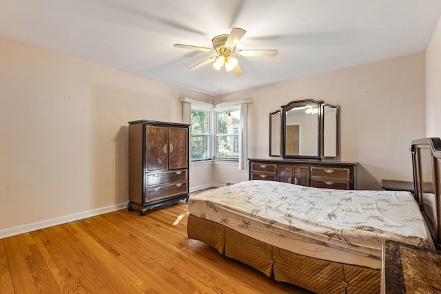 bedroom featuring light wood-style flooring, a ceiling fan, and baseboards