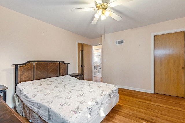 bedroom featuring ceiling fan, visible vents, baseboards, and wood finished floors