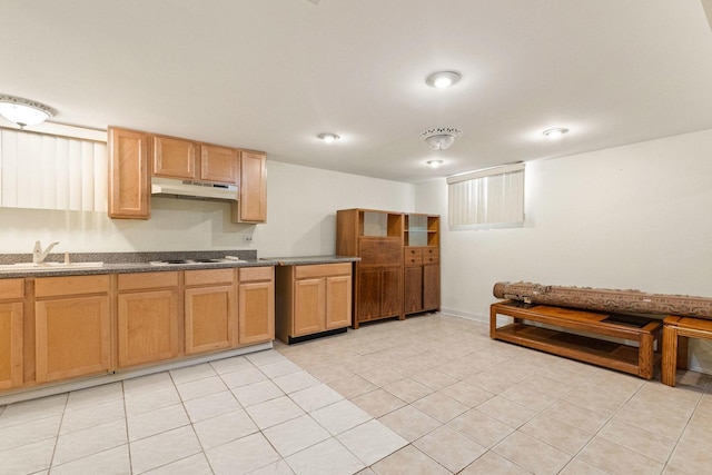 kitchen featuring a sink, under cabinet range hood, dark countertops, light tile patterned floors, and white cooktop