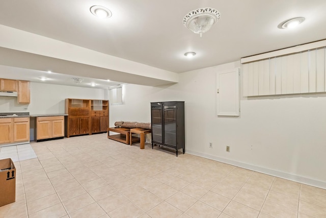 finished below grade area featuring light tile patterned floors and baseboards