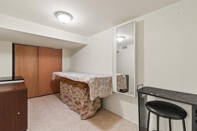 bedroom with light tile patterned floors, visible vents, and baseboards