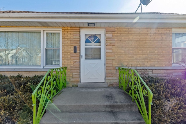 view of exterior entry with brick siding