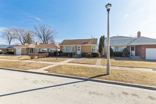 ranch-style house featuring an attached garage and a front lawn