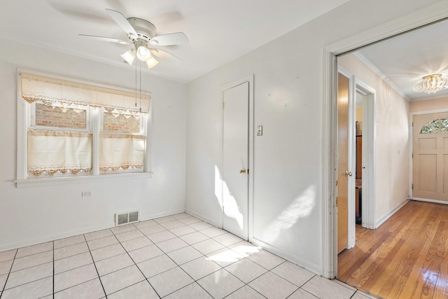 interior space with light tile patterned floors, visible vents, crown molding, and baseboards