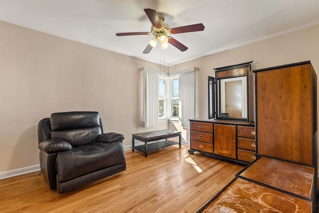 sitting room with baseboards, light wood finished floors, and ceiling fan