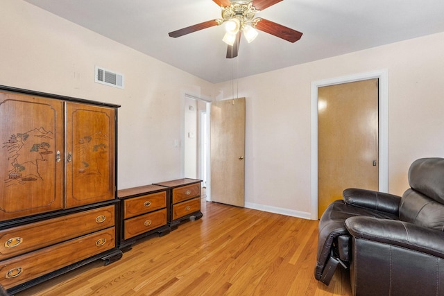 living area with a ceiling fan, light wood-style floors, visible vents, and baseboards