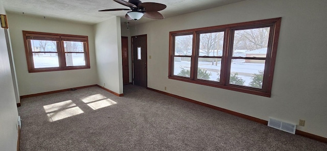 empty room with a healthy amount of sunlight, light colored carpet, and ceiling fan