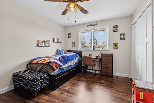 bedroom with baseboards, visible vents, ceiling fan, wood finished floors, and a closet