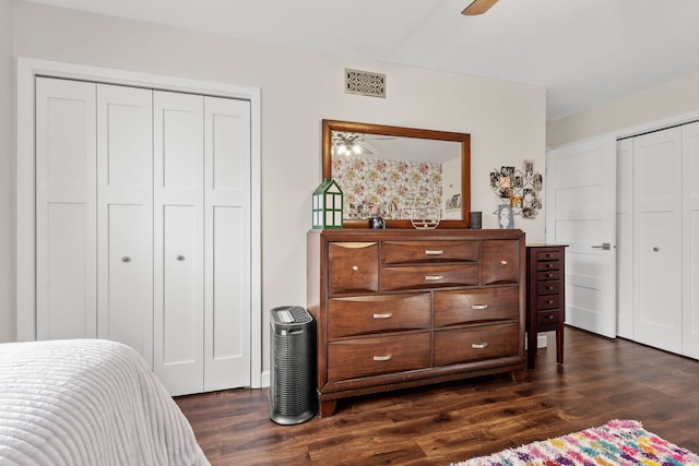 bedroom with a ceiling fan, visible vents, and dark wood finished floors