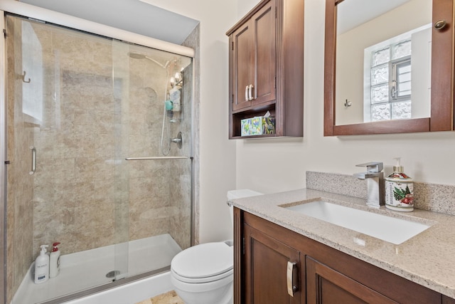 full bath featuring toilet, a stall shower, and vanity