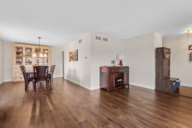 dining room featuring dark wood-style flooring, visible vents, and baseboards