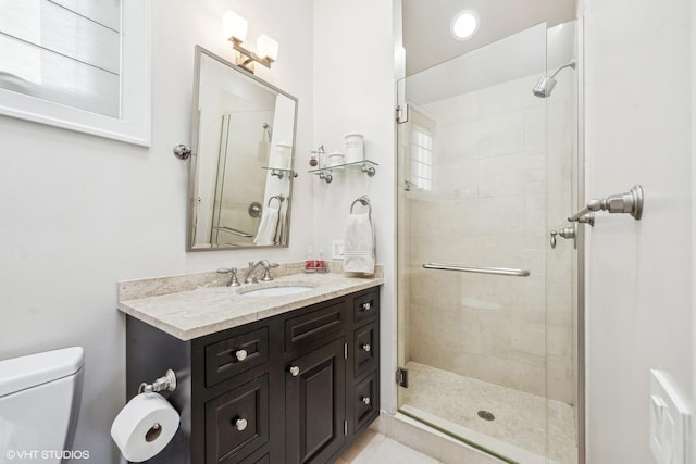 bathroom featuring vanity, toilet, and a shower stall