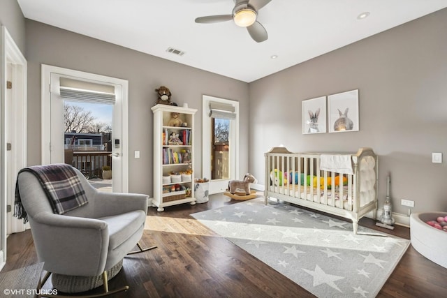 bedroom with visible vents, ceiling fan, baseboards, and wood finished floors