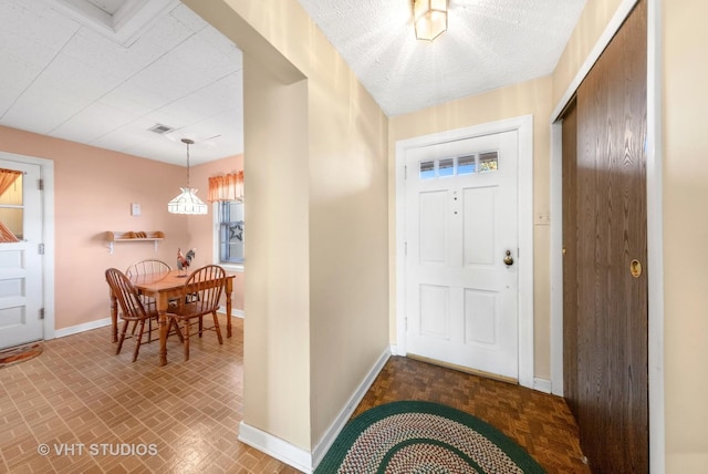 entryway with visible vents, a textured ceiling, and baseboards