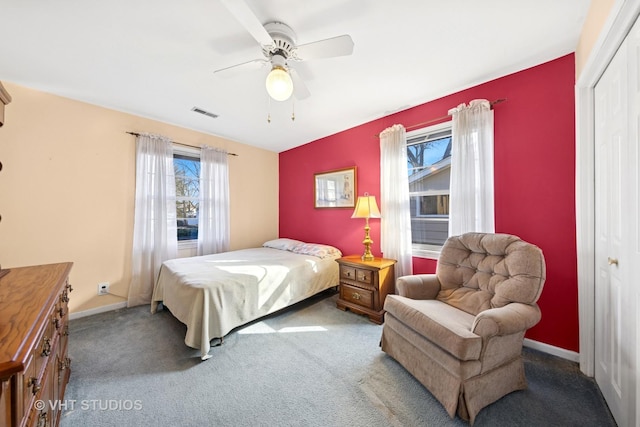 carpeted bedroom featuring a closet, visible vents, ceiling fan, and baseboards