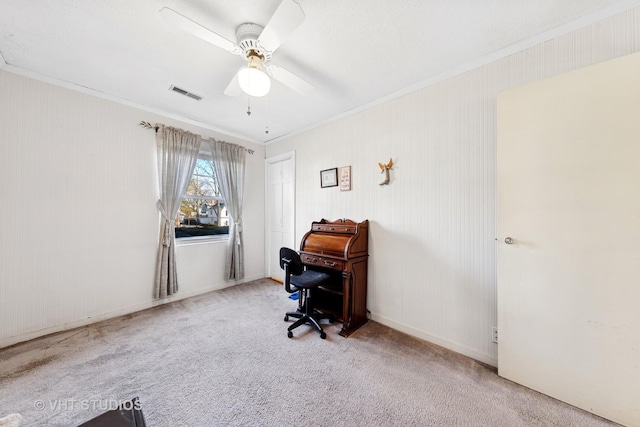 carpeted office featuring visible vents, baseboards, crown molding, and a ceiling fan