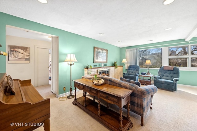 living area with baseboards, recessed lighting, a fireplace, a textured ceiling, and light carpet