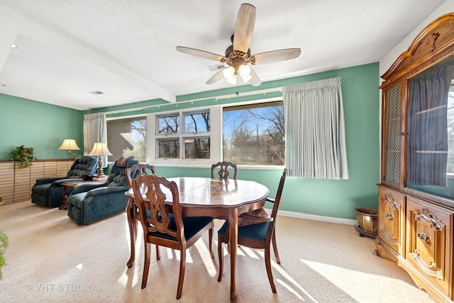 dining space featuring a wealth of natural light, light colored carpet, a textured ceiling, and a ceiling fan