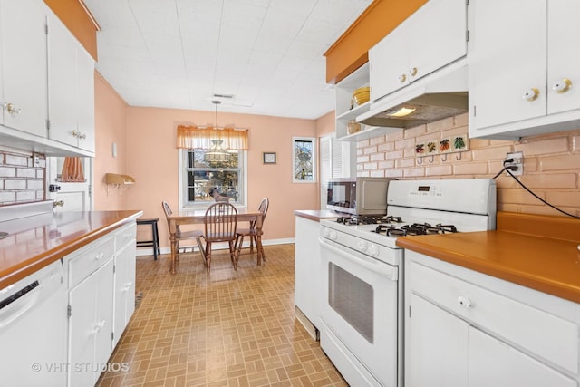 kitchen with under cabinet range hood, white appliances, and white cabinetry