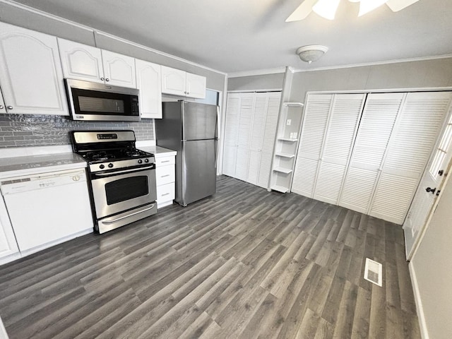 kitchen featuring white cabinetry, ornamental molding, appliances with stainless steel finishes, and dark wood-type flooring