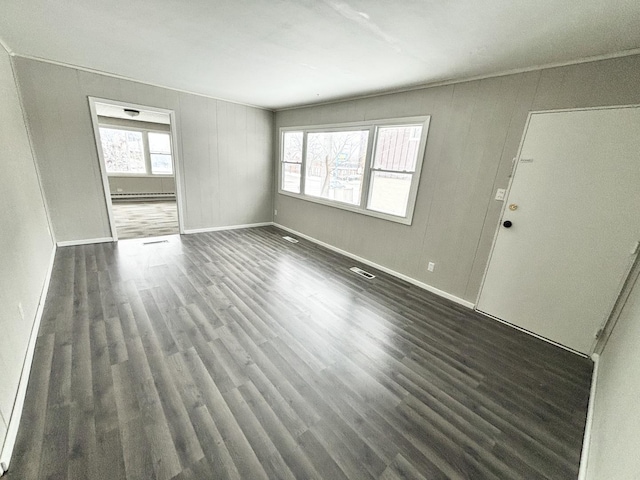 unfurnished living room with a baseboard radiator and dark wood-type flooring