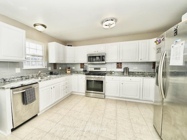 kitchen featuring stainless steel appliances, sink, white cabinets, and decorative backsplash