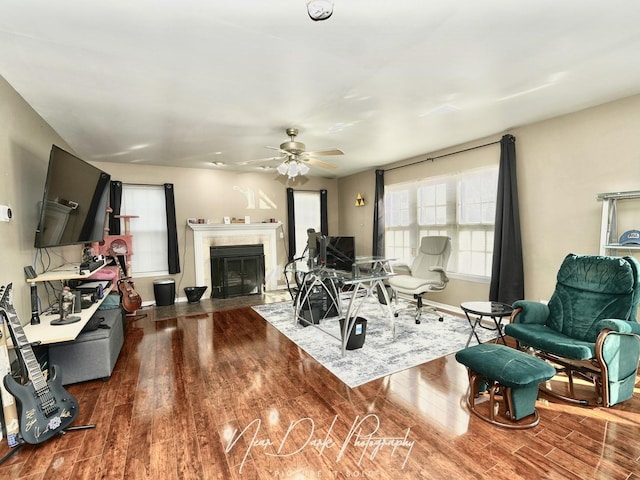 living room with ceiling fan, dark hardwood / wood-style flooring, and a tile fireplace