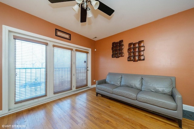 living room with ceiling fan, light hardwood / wood-style flooring, and lofted ceiling