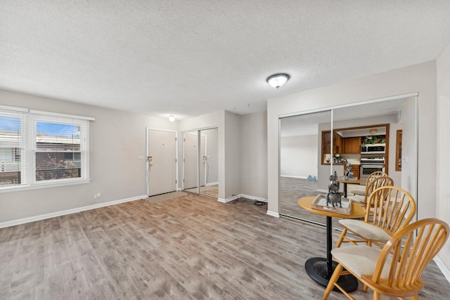 living area featuring a textured ceiling and light hardwood / wood-style floors