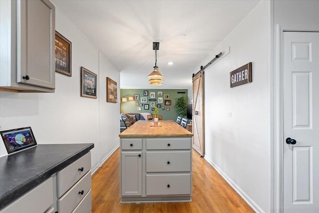 kitchen with gray cabinets, light wood finished floors, and a barn door