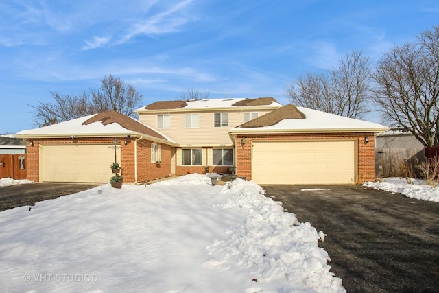 traditional-style house featuring brick siding, driveway, and an attached garage