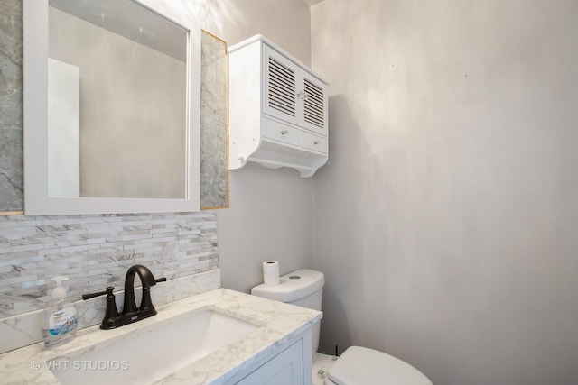 bathroom with toilet, tasteful backsplash, and vanity