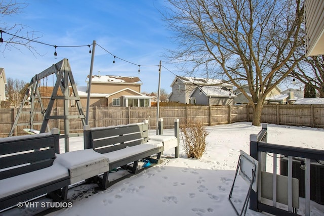 snowy yard with a fenced backyard