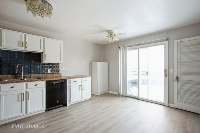 kitchen featuring black dishwasher, white cabinets, a sink, and light wood-style flooring