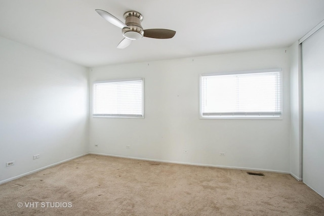 unfurnished room featuring light carpet, ceiling fan, visible vents, and baseboards