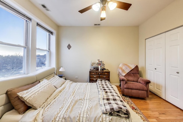 bedroom with a ceiling fan, a closet, visible vents, and light wood-style floors