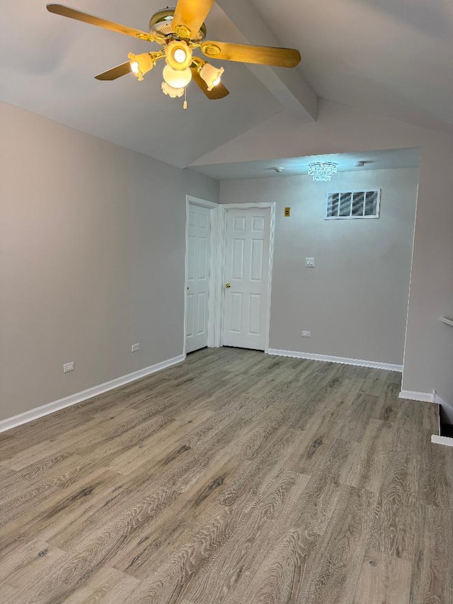 empty room with vaulted ceiling with beams, hardwood / wood-style flooring, and ceiling fan