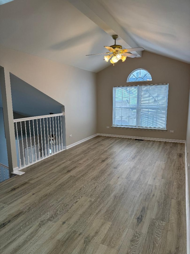 empty room with vaulted ceiling with beams, hardwood / wood-style floors, and ceiling fan